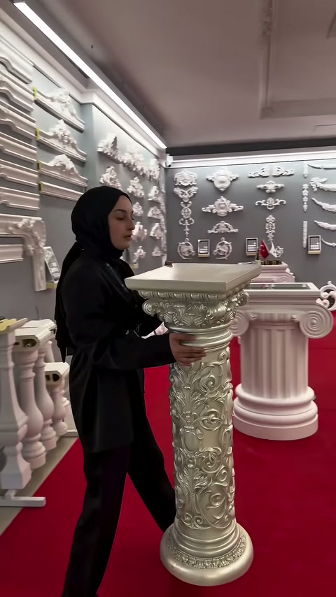 Metalik renkli sütun sehpanın tablası elle hizalanarak düzenleniyor.