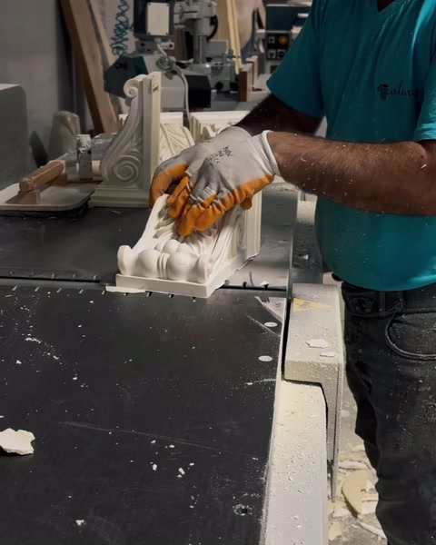 Turuncu eldivenli isci sutun basligindaki rolyef detayini isliyor