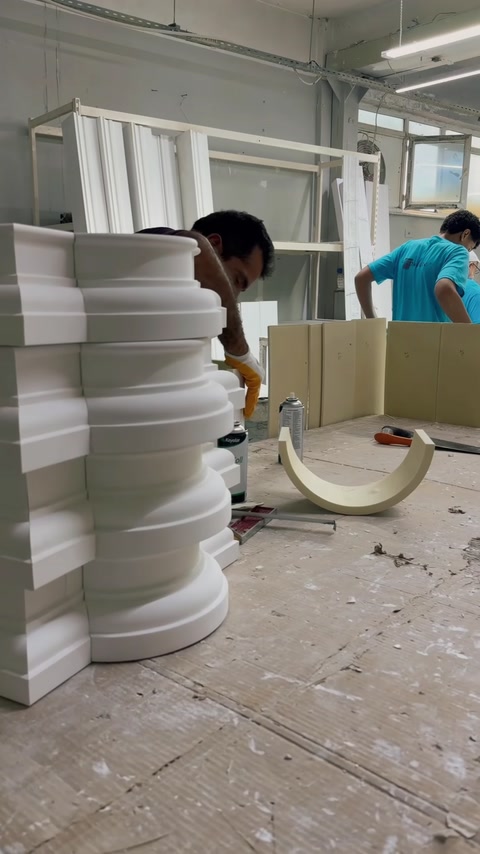 İstiflenmiş kavisli profiller ve çalışma masasındaki kemer parçası görülüyor