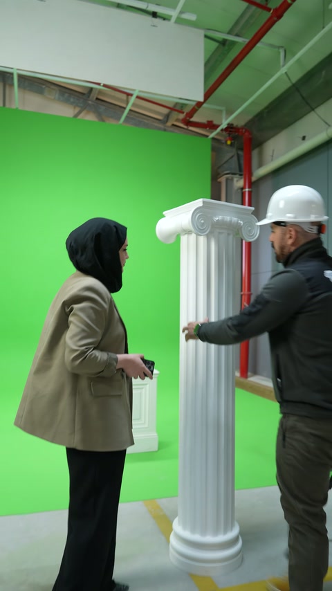 Usta dekoratif sütunu gövdesinden tutarak dik konumda dengeliyor