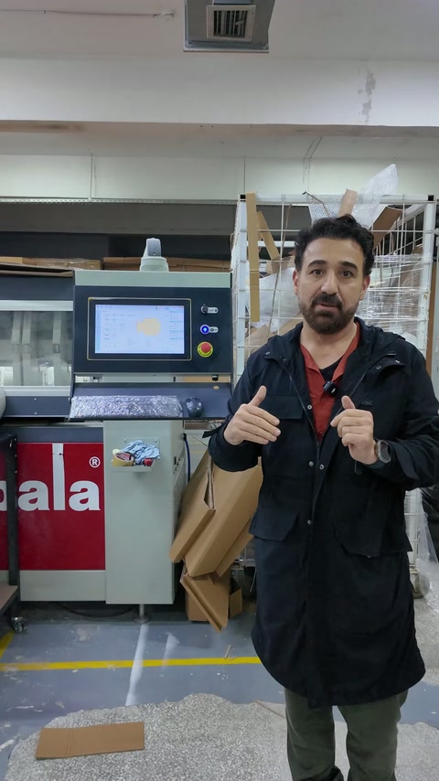 Üretici, makine ve paketleme malzemeleri önünde açıklama yapıyor.