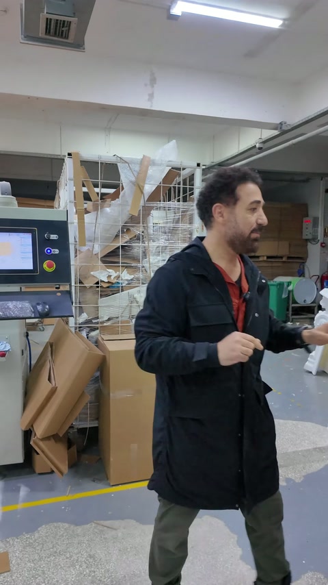 Usta, açık karton kutunun yanında paketleme sürecini anlatıyor.