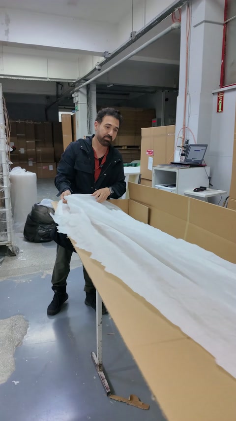 Kutudaki uzun profiller beyaz koruyucu örtüyle kaplanmaya hazırlanıyor.
