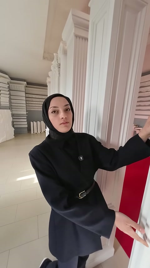 Sunucu, sütunun dikey yivleri boyunca yüzey ayrıntısını eliyle anlatıyor.