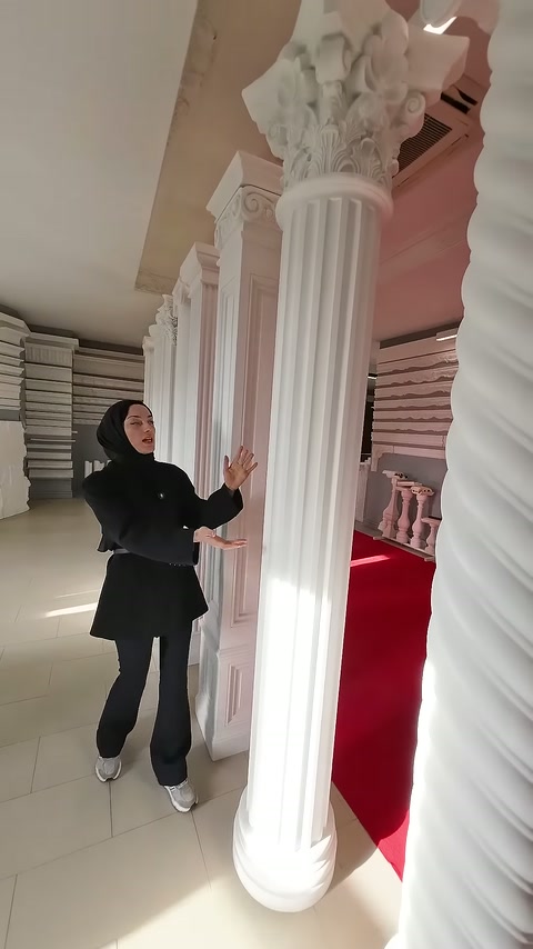 Sunucu, akantus başlıklı yivli sütunun gövdesini eliyle gösteriyor.