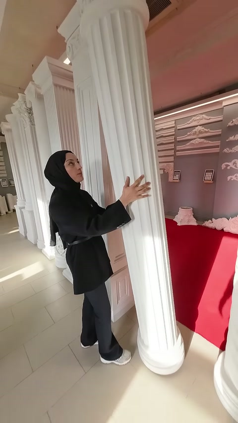 Sunucu, yivli sütunun alt bölümünü tutarak yüzeyini inceliyor.