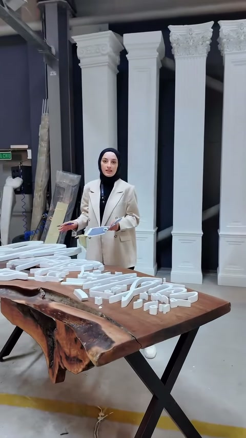 Sunucu, elindeki örnekle masadaki beyaz harfleri karşılaştırıyor.