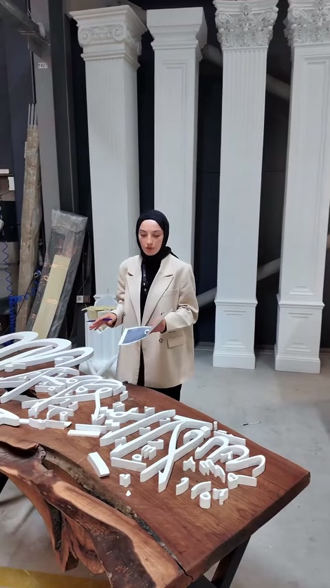 Beyaz logo parçaları sütun örnekleri önündeki masada gözden geçiriliyor.