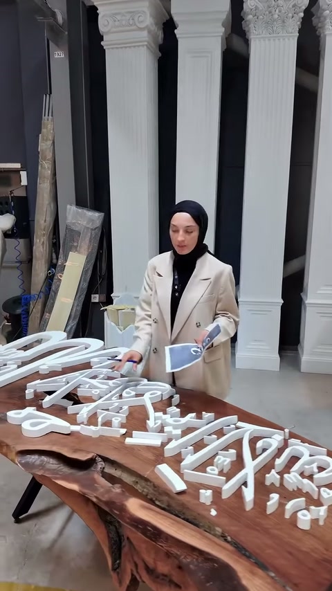 Kıvrımlı poliüretan yazılar ve küçük semboller birlikte sergileniyor.