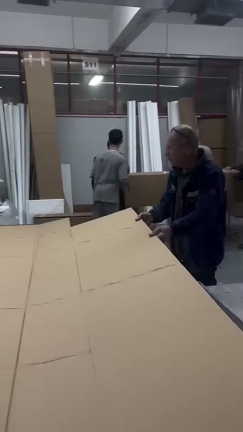 Çalışanlar uzun kutu için karton yüzeyleri katlamaya hazırlanıyor