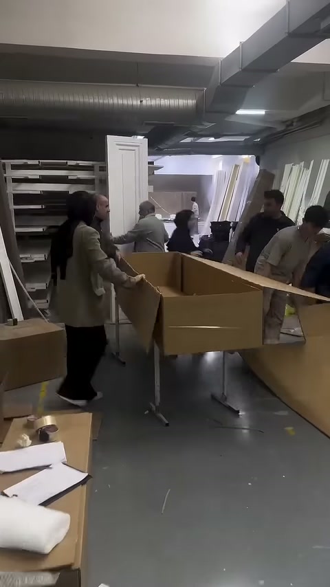 Uzun ürün kutusu birkaç çalışan tarafından tezgâhta şekillendiriliyor