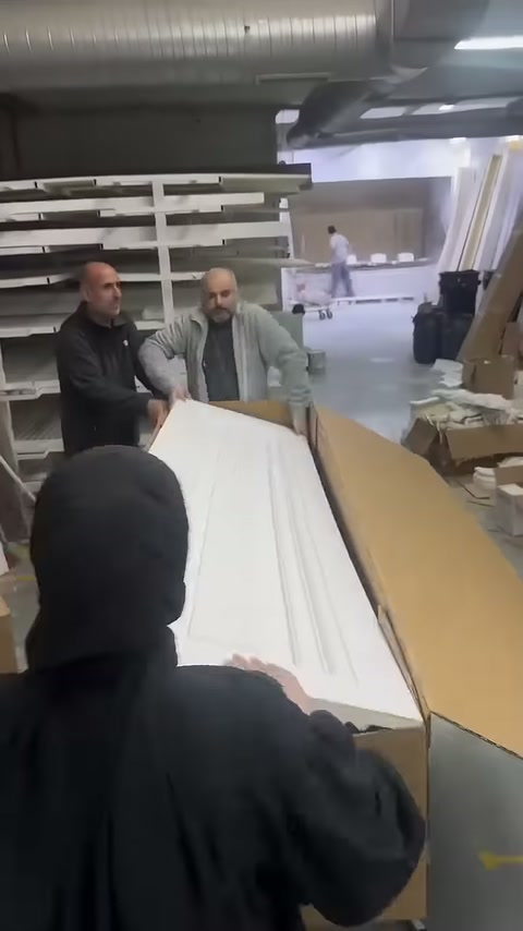 Uzun beyaz dekoratif profiller hazırlanan karton kutuya uzatılıyor
