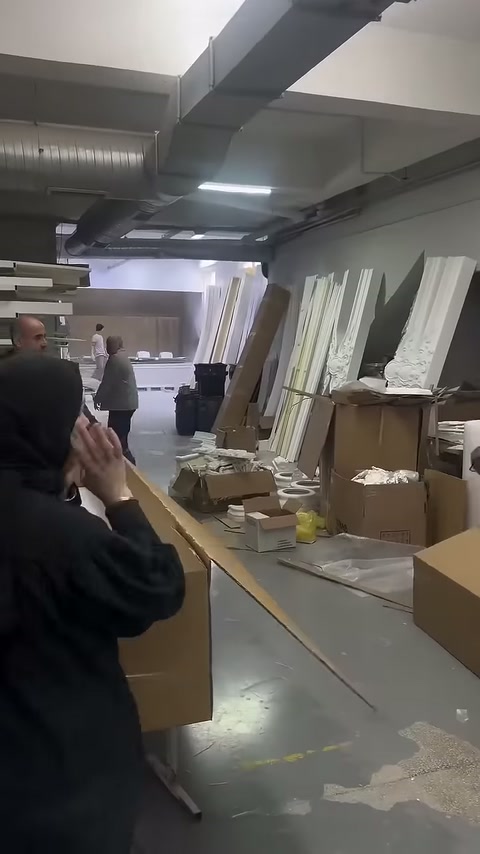 Çalışan kutu içindeki profillerin üzerindeki örtüyü eliyle düzeltiyor