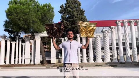 Görevli altın renkli klasik sütun başlığını yukarıda taşıyor