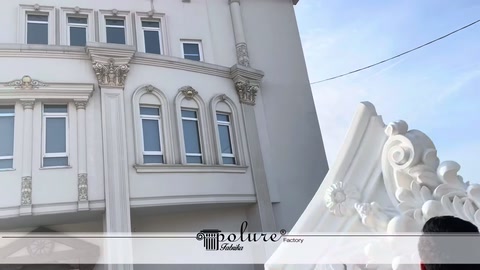Dekoratif bina cephesi önünde beyaz başlığın kenarı görülüyor