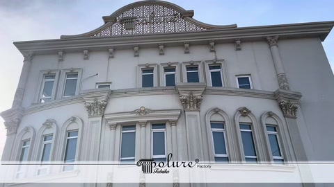 Beyaz yapının simetrik pencereleri ve kabartmalı cephesi tanıtılıyor