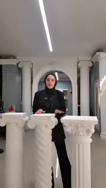 Sunucu küçük kare tablalı sehpanın arkasında ellerini uzatıyor.