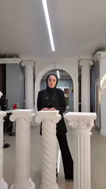 İki klasik sehpa, sütunlu showroom dekoru önünde tanıtılıyor.