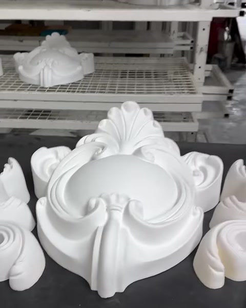 Simetrik dekoratif kompozisyon oluşturan beyaz taç motifleri masada duruyor