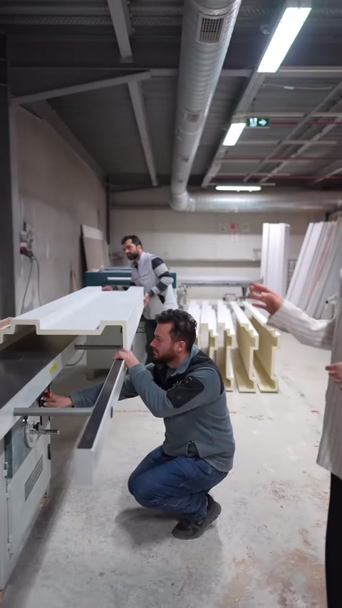 Kesim öncesinde çalışan, tezgâh mekanizmasını alçak konumdan inceliyor.