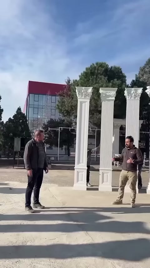 İki çalışan açık alandaki sütun düzeninin yanında hazırlık yapıyor