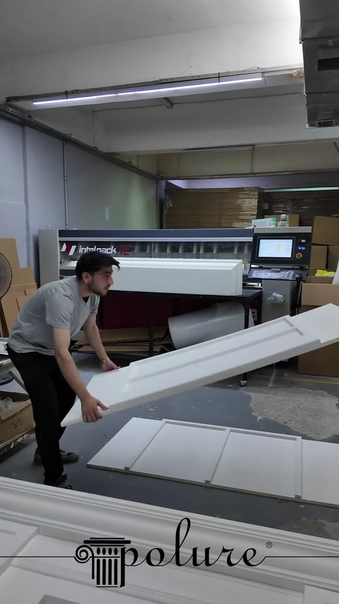 Çalışan uzun üst silme parçasını şömine panellerine yerleştiriyor.
