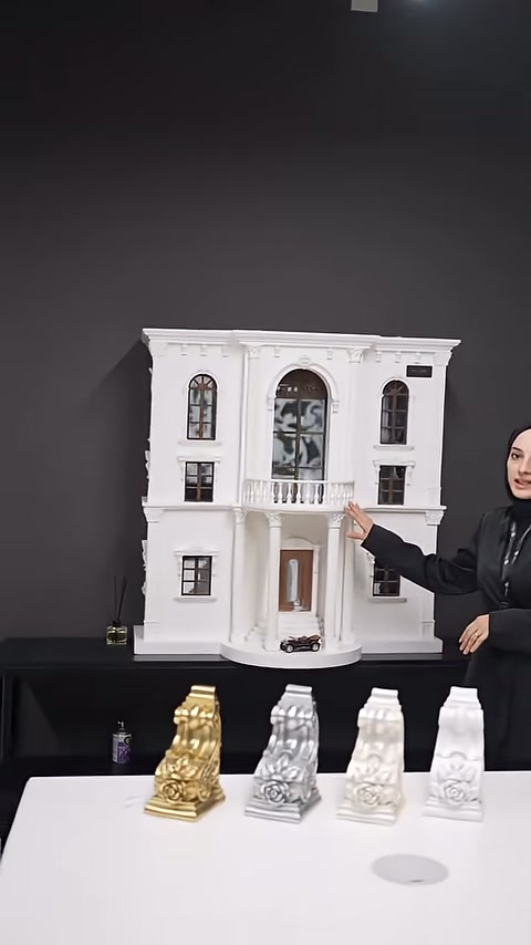 Beyaz cephe maketi önünde farklı renklerde payanda numuneleri sıralanıyor