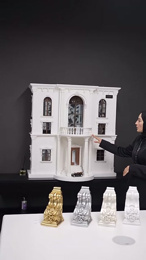 Sunucu, maketin üst katındaki pencere ve balkon düzenini işaret ediyor