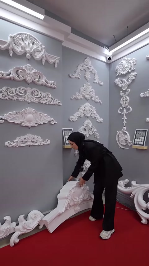 Sunucu zemindeki büyük kavisli taç motifini dikkatlice kaldırıyor