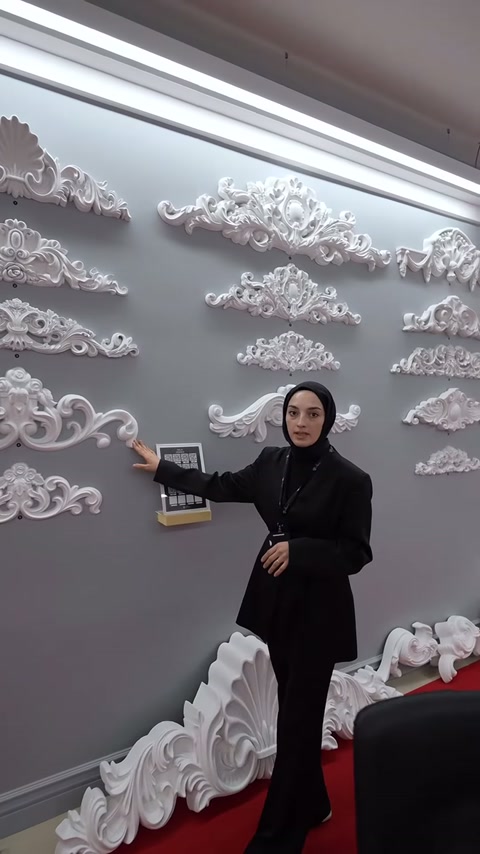Sunucu duvara sıralanmış uzun ve küçük taç motiflerini açıklıyor.
