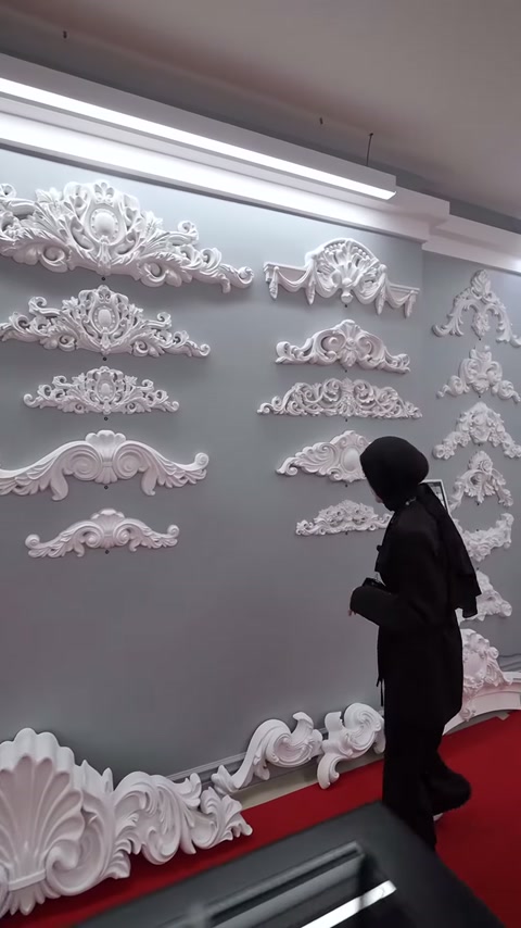 Sunucu alt sıradaki geniş kavisli dekoratif parçaları inceliyor.