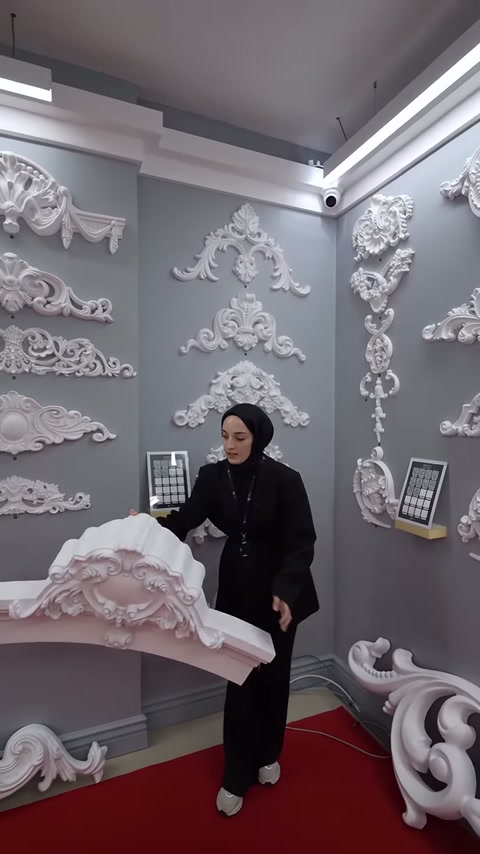Kabartmalı merkez süsü bulunan geniş kavisli parça aşağı indiriliyor.