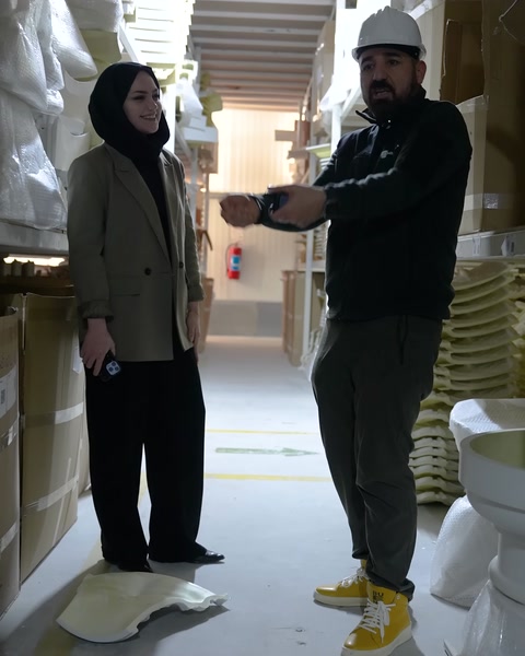 Baretli görevli, küçük ürün parçasını elinde yakından gösteriyor.