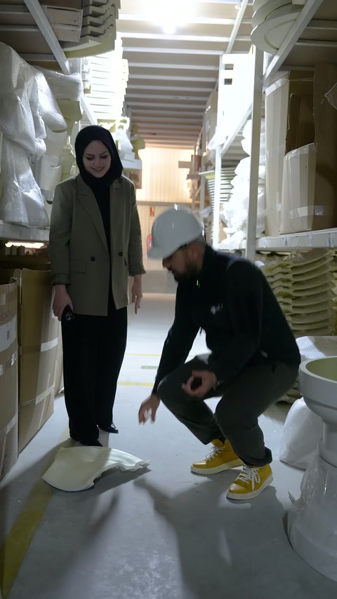 Görevli zemindeki geniş süsleme elemanını almak için çömeliyor