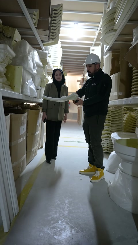 Büyük beyaz süsleme elemanı zeminden iki elle kaldırılıyor
