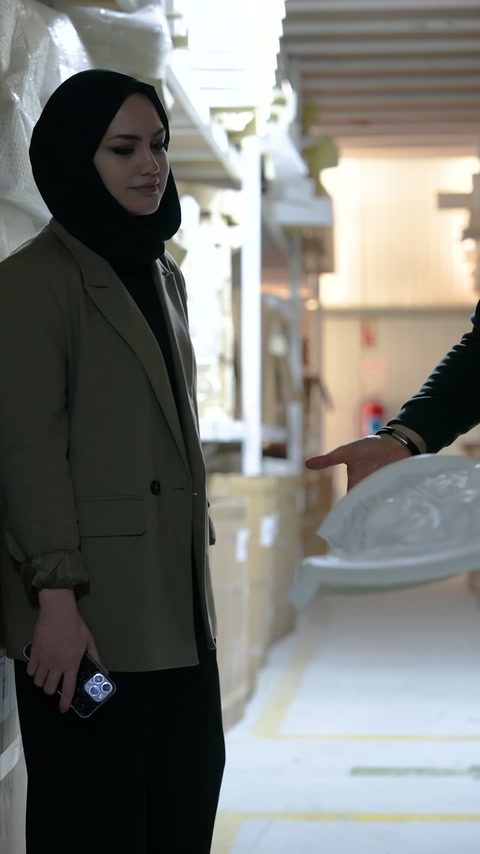 Kabartmalı geniş dekoratif eleman iki görevlinin önünde tutuluyor