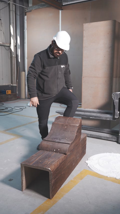 Ahşap dokulu içi boş kiriş üzerinde dayanıklılık gösterisi yapılıyor.
