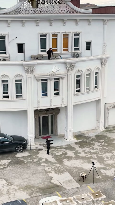 Beyaz yapının avlusunda havadaki dekoratif parça aşağı doğru ilerliyor.