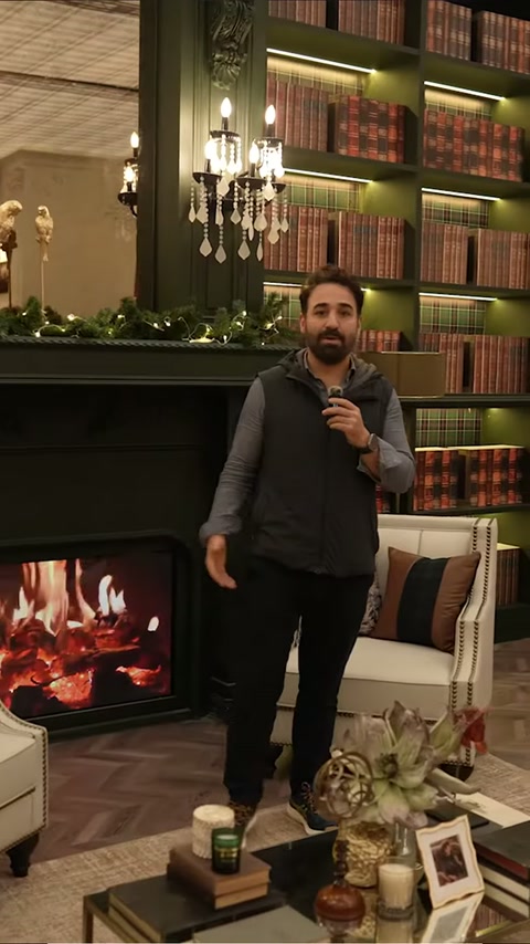 Sunucu, kitaplıklarla çevrili şömine ve duvar panellerini tanıtıyor