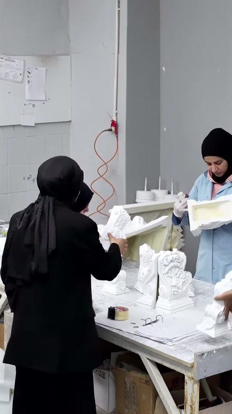 Çalışma masasında çeşitli küçük süsleme parçaları dikkatle inceleniyor.