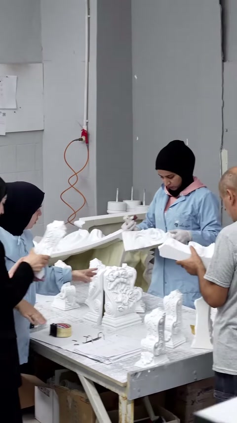 Eldivenli personel uzun beyaz parçayı tutarken sunucu detayları izliyor.