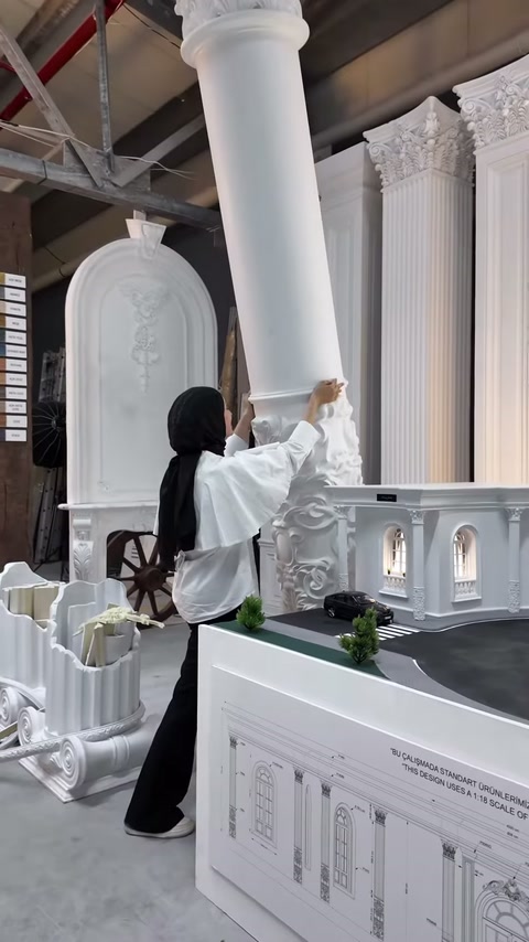 Showroomdaki uzun düz sütunlar gösterişli başlıklar ve kaidelerle sergileniyor.
