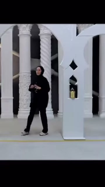 Sunucu, geometrik kesimli kemer panelinin önünde tasarımı anlatıyor.