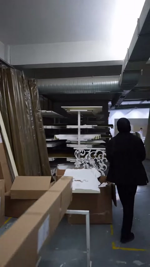 Kutu ve profil yığınlarının arasından süslemeli panele doğru ilerleniyor.