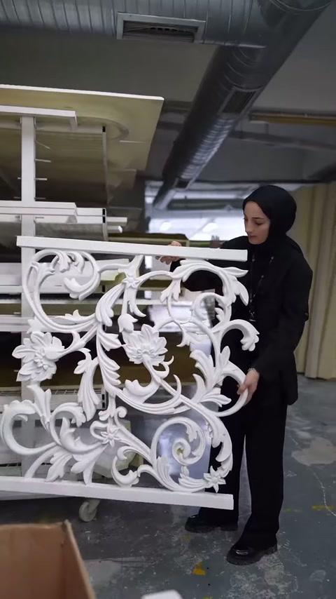 Beyaz dekoratif korkulukta simetrik kıvrımlar ve yaprak motifleri sergileniyor.