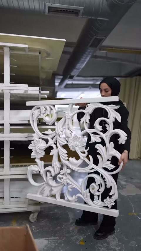 Sunucu, ajurlu panelin merkezindeki kabartmalı desenleri eliyle belirtiyor.