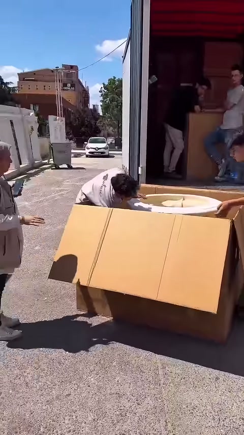 Çalışanlar ürüne ulaşmak için karton kapakları kenarda tutuyor
