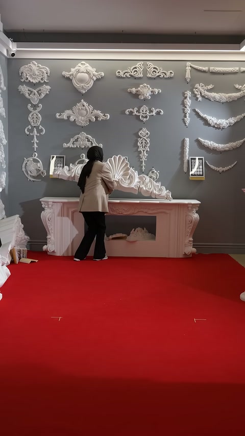 Sunucu, pembe şömine ve duvar süsleri önünde ürüne yöneliyor.
