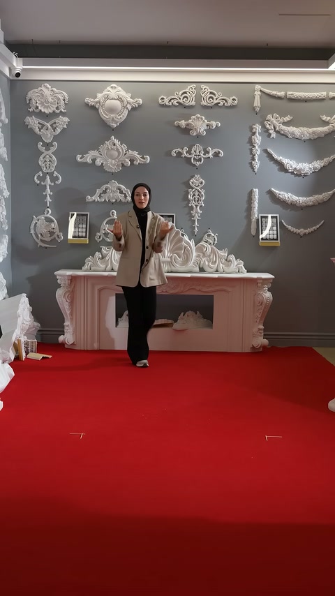 Sunucu, pembe şömine önünde ürünü el hareketleriyle anlatıyor.