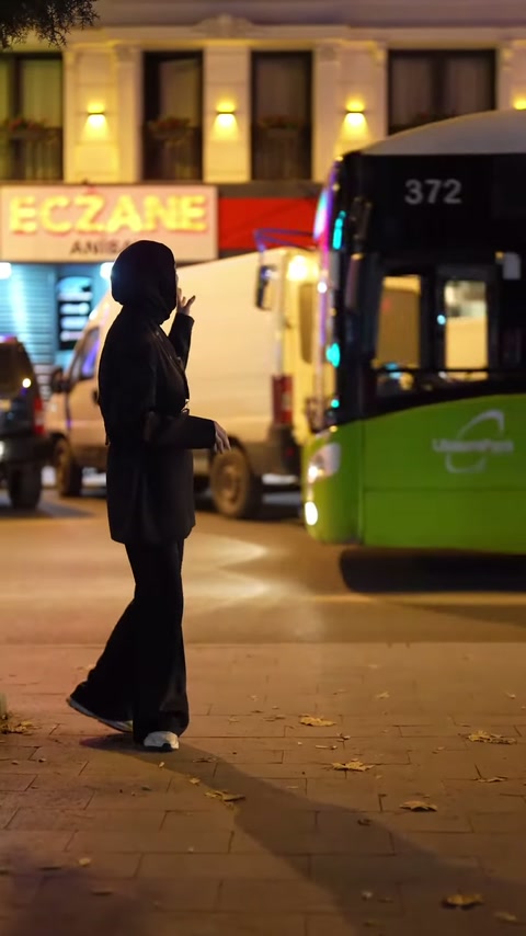 Hareketli otobüs ön plandan geçerken aydınlatılmış cephe sunumuna devam ediliyor.